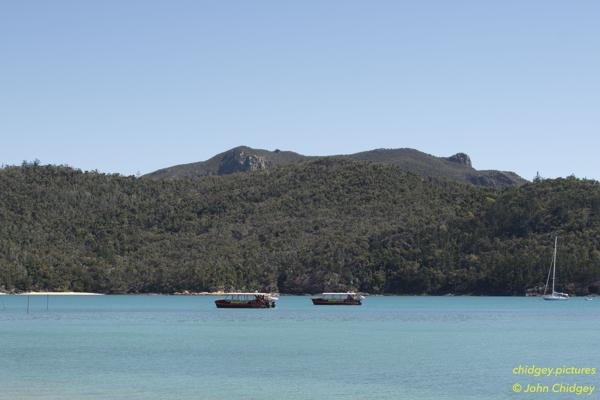 Tongue Bay Looking Inland: During a break in the COVID19 lockdowns and restricted to travel within our own state only, we trekked to the amazing Whitehaven Beach in the Whitsunday Islands in June, 2020. This photo is taken from Tongue Bay looking over the bay towards the mountain range, with two tour boats in the distance, anchored waiting for the bushwalkers to return for lunch.